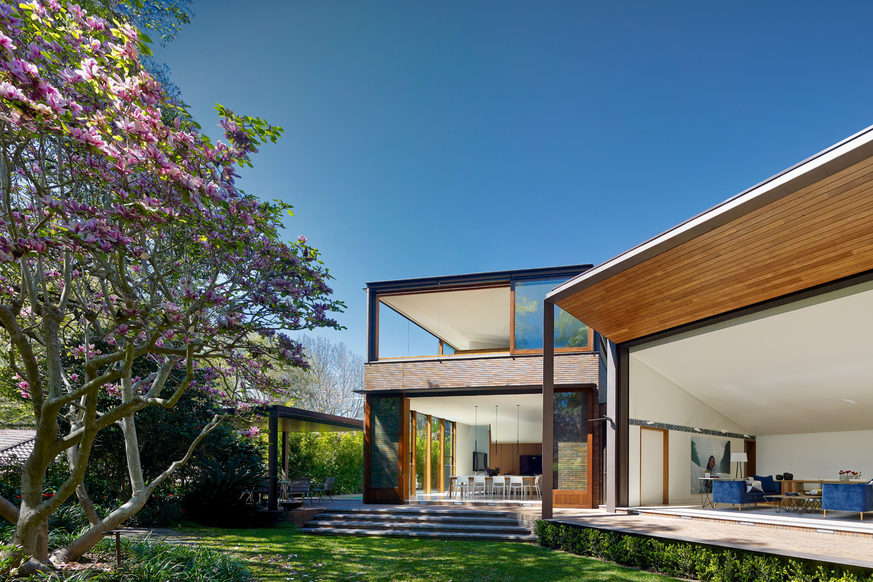 Photograph of dining and living spaces from the garden in the Garden House designed by Tzannes