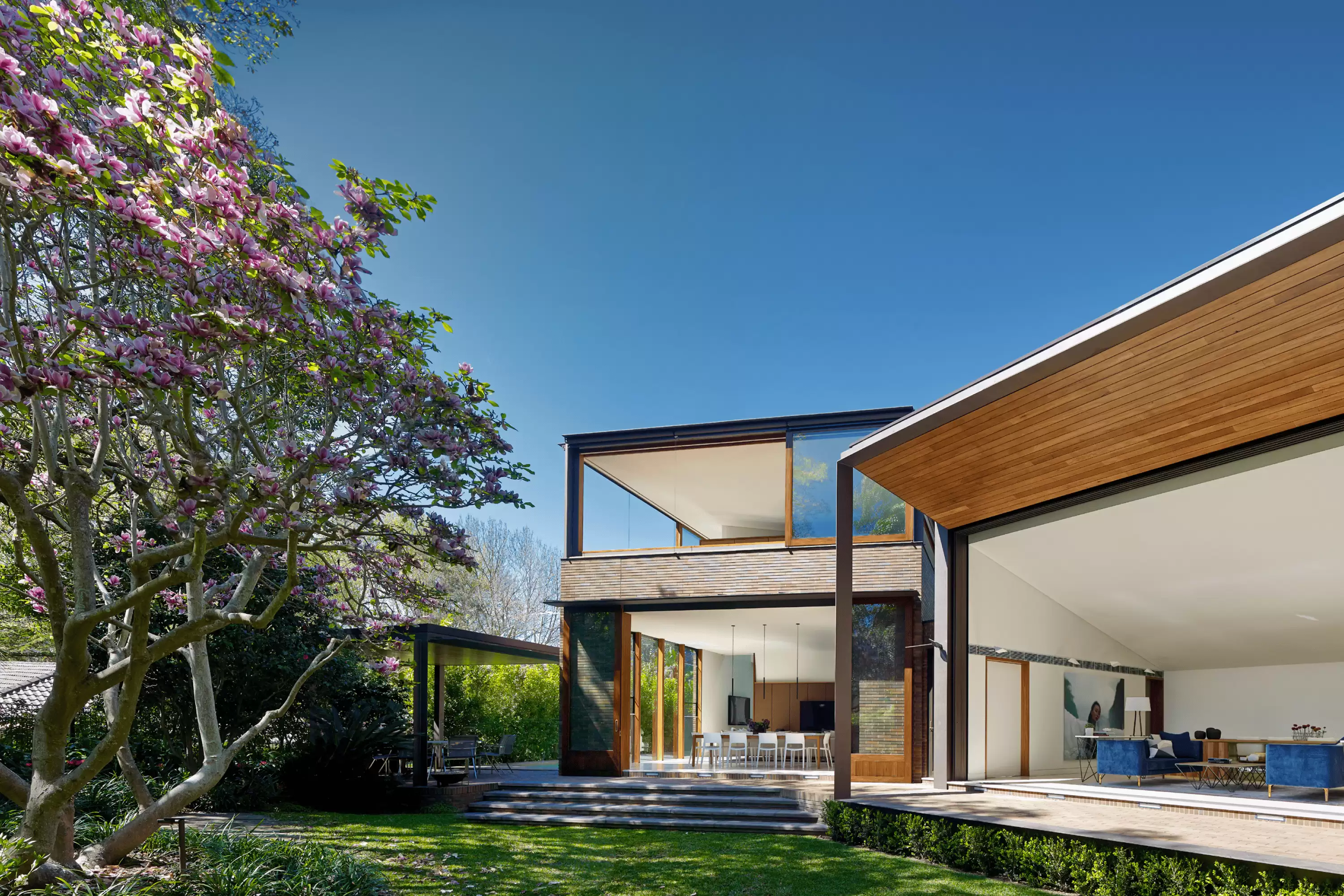 Photograph of dining and living spaces from the garden in the Garden House designed by Tzannes