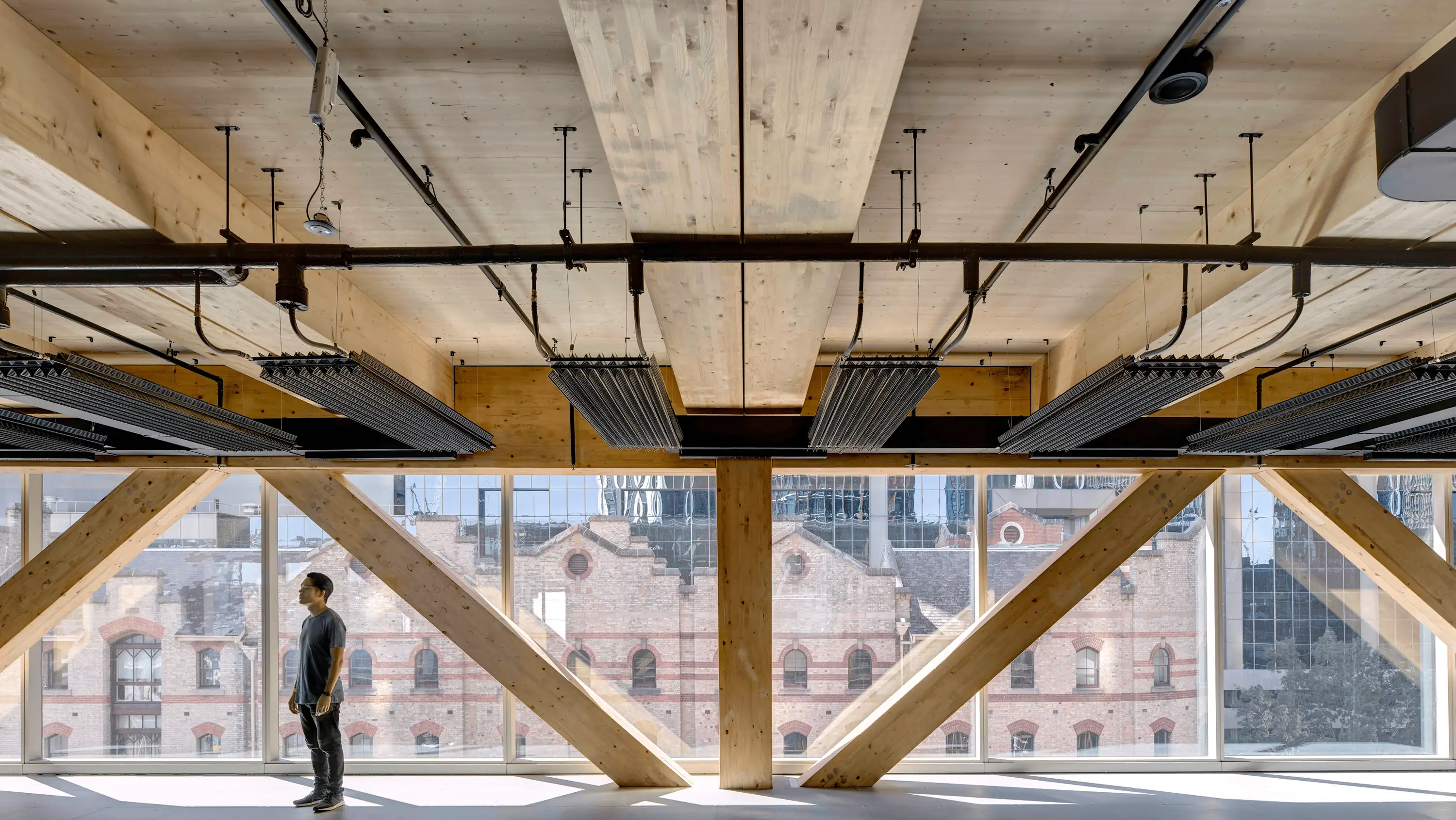 Photograph of typical internal commercial floor with exposed ceiling and services revealing mass timber structural floors and framing